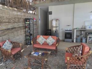 a living room with two chairs and a table at La casa de Joan in Máncora