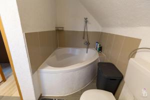 a bath tub in a bathroom with a toilet at Hochrhein Ferienwohnung in Albbruck +22 photos
