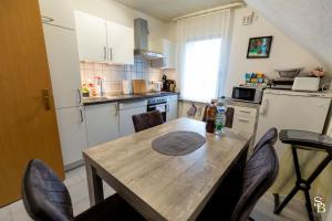 a kitchen with a wooden table and chairs in a kitchen at Hochrhein Ferienwohnung in Albbruck