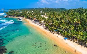 an aerial view of a beach with palm trees at Kumara villa in Hikkaduwa