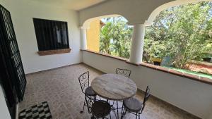 a balcony with a table and chairs and a window at Casa Kalily Sol in Playa del Carmen