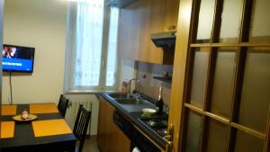 a kitchen with a sink and a table and a tv at FamilyBed Roma Monteverde-Vaticano in Rome
