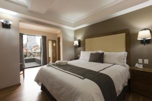 una camera da letto con un letto grande e una grande finestra di Historico Central Hotel a Città del Messico