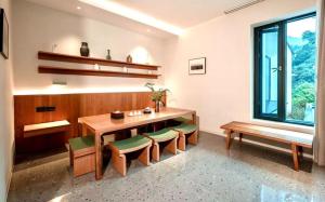 a dining room with a table and chairs and a window at 峨眉山和院一溪清音酒店 in Emeishan City