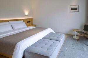 a bedroom with a large bed and a chair at 峨眉山和院一溪清音酒店 in Emeishan City