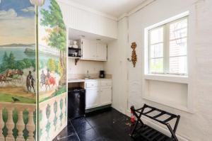 a kitchen with a large painting on the wall at Chic Cottage near the Lower French Quarter in New Orleans