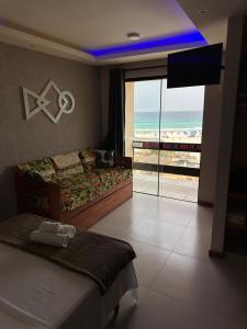 a bedroom with a bed and a view of the ocean at Varandas ao mar loft 302 Praia Grande in Arraial do Cabo +28 photos