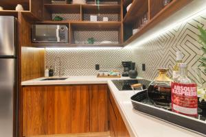 a kitchen with wooden cabinets and a bottle of alcohol at Stunning 2BR with Plunge Pool - Rooftop Sea Views in Playa del Carmen