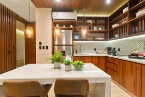 a kitchen with a large white table and chairs at Stunning 2BR with Plunge Pool - Rooftop Sea Views in Playa del Carmen