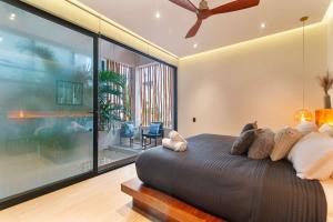 a bedroom with a large bed and a large window at Stunning 2BR with Plunge Pool - Rooftop Sea Views in Playa del Carmen