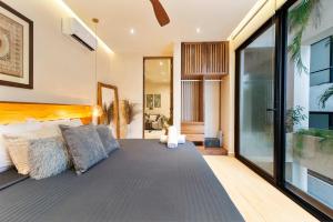 a bedroom with a bed and a large window at Stunning 2BR with Plunge Pool - Rooftop Sea Views in Playa del Carmen