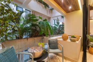 a patio with a table and chairs and plants at Stunning 2BR with Plunge Pool - Rooftop Sea Views in Playa del Carmen