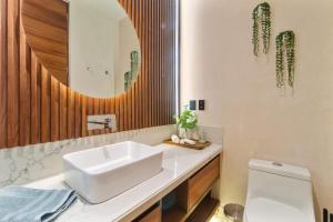 a bathroom with a white sink and a mirror at Stunning 2BR with Plunge Pool - Rooftop Sea Views in Playa del Carmen