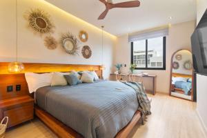 a bedroom with a large bed and a ceiling fan at Stunning 2BR with Plunge Pool - Rooftop Sea Views in Playa del Carmen
