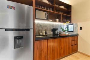 a kitchen with a stainless steel refrigerator and a counter at Stunning 2BR with Plunge Pool - Rooftop Sea Views in Playa del Carmen