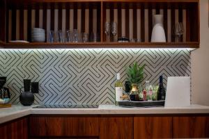 a kitchen counter with a shelf with wine bottles and glasses at Stunning 2BR with Plunge Pool - Rooftop Sea Views in Playa del Carmen