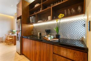 a kitchen with wooden cabinets and a black counter top at Stunning 2BR with Plunge Pool - Rooftop Sea Views in Playa del Carmen