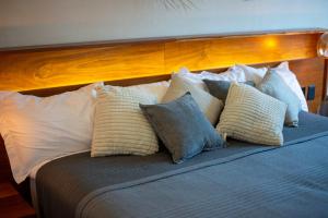 a bed with white and blue pillows on it at Stunning 2BR with Plunge Pool - Rooftop Sea Views in Playa del Carmen