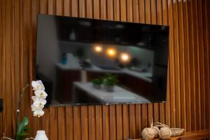 a flat screen tv hanging on a wooden wall at Stunning 2BR with Plunge Pool - Rooftop Sea Views in Playa del Carmen