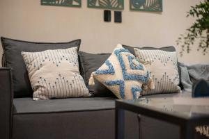 a gray couch with pillows on it with a table at Stunning 2BR with Plunge Pool - Rooftop Sea Views in Playa del Carmen