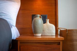 two vases sitting on a table next to a bed at Stunning 2BR with Plunge Pool - Rooftop Sea Views in Playa del Carmen