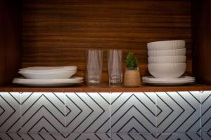 a shelf with plates and bowls and glasses on it at Stunning 2BR with Plunge Pool - Rooftop Sea Views in Playa del Carmen