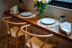 a table with two plates and a vase of flowers at Stunning 2BR with Plunge Pool - Rooftop Sea Views in Playa del Carmen