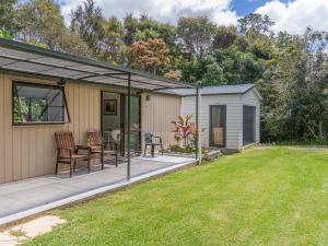 a screened in porch of a house with a yard at Rewa Rewa Retreat - Tairua Holiday Home in Tairua