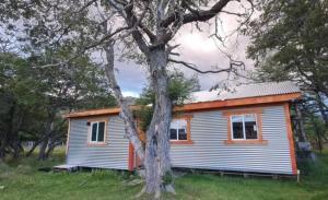 百内三塔Cabaña Nutria的田野上的小房子,有树