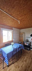 a kitchen with a table with a blue and white checkered table cloth at Cabaña Nutria in Torres del Paine