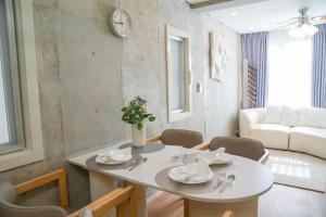 Una sala de estar con una mesa y sillas blancas. en Midland Hotel-秋葉原8分4階建て4LDK貸切別荘, en Tokio