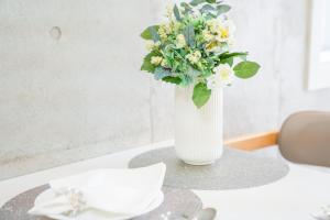 Un jarrón lleno de flores sobre una mesa. en Midland Hotel-秋葉原8分4階建て4LDK貸切別荘, en Tokio 45 fotos más