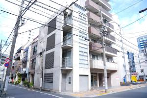 Un edificio de apartamentos en una calle de la ciudad con líneas eléctricas en Midland Hotel-秋葉原8分4階建て4LDK貸切別荘, en Tokio