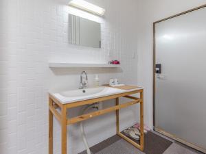 高松市にあるTabist ホテル吉泊の洗面台と鏡のある白いバスルーム
