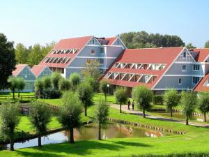 a group of buildings with a river in front of it at Luxe Glamping Getaway in Bruinisse