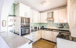 a kitchen with white cabinets and white appliances at Urb San Luis in Torrevieja