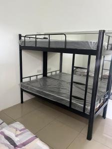 two bunk beds in a room next to a bed at Hostel TTDI in Shah Alam