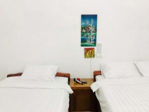 two beds sitting next to each other in a room at Agarwood in Hanoi