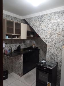 une cuisine avec un comptoir noir et une cuisinière dans l'établissement Casa temporada Caípe, à São Francisco do Conde