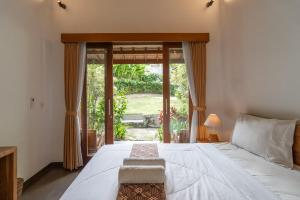 チャングーにあるJinar Guest Houseの大きなベッドと大きな窓のある寝室