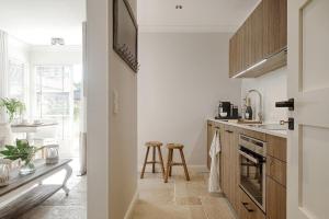a kitchen with white walls and wooden cabinets at Seahorse-Ferienwohnung-2 in Westerland (Sylt)