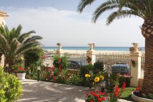 een tuin met bloemen en het strand op de achtergrond bij Gran Sol in Zahara de los Atunes