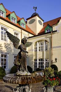 a statue of a man sitting on top of a fountain at Parkhotel Engelsburg in Recklinghausen