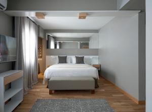 a bedroom with a white bed and a tv at Hotel Arenales in Buenos Aires