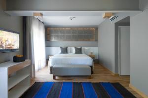 a bedroom with a bed and a blue rug at Hotel Arenales in Buenos Aires