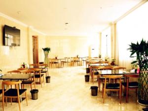 a dining room with tables and chairs and a cafeteria at GreenTree Inn Jiangxi Shangrao Qianshan Ehu Avenue Express Hotel in Shangrao