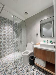 a bathroom with a shower and a toilet and a sink at Tiny House Phu Quoc in Phú Quốc +73 photos