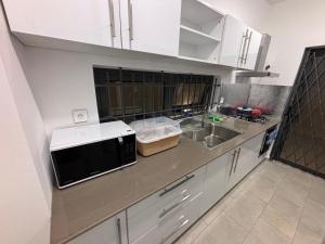una cucina con forno a microonde e lavandino di J'Vais Residence by SOV a Flic-en-Flac