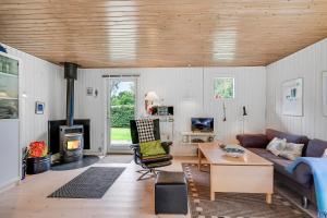 un salon avec un canapé et une cheminée dans l'établissement Well-Maintained Vacation Home Close To A Lovely Bathing Beach, à Ebeltoft
