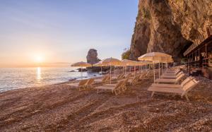 a group of chairs and umbrellas on a beach at UNA HOTELS Capotaormina in Taormina
